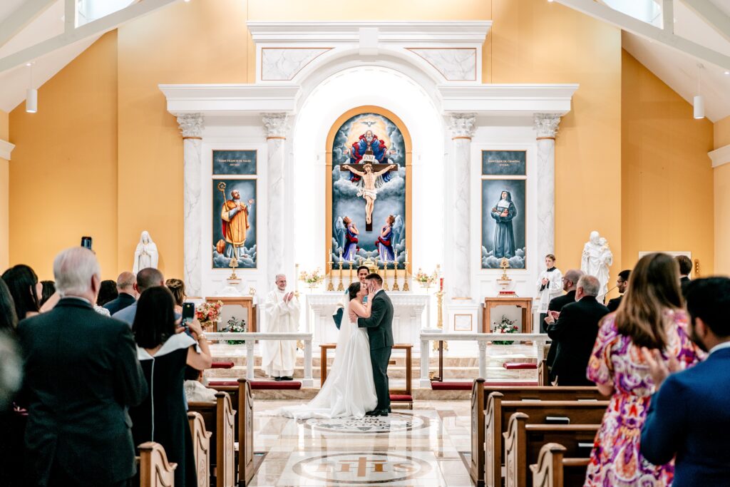 A bride and groom's first kiss during their church wedding
