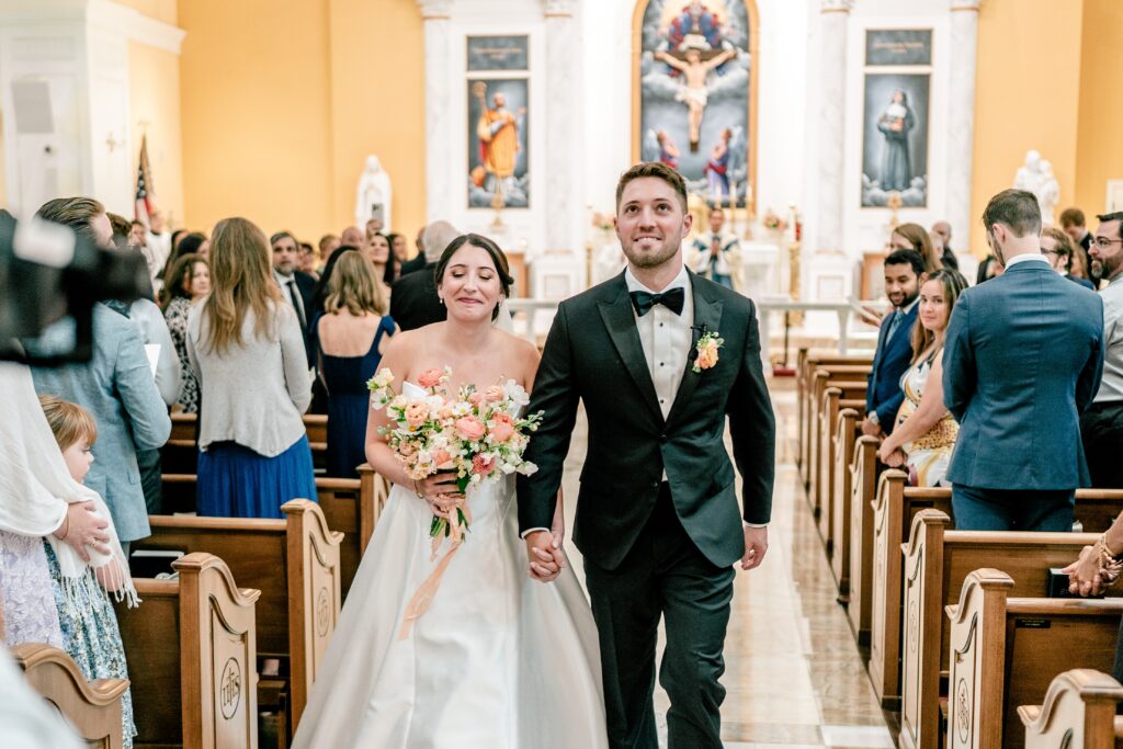 A bride and groom recessing from the church before their Shadow Creek wedding reception