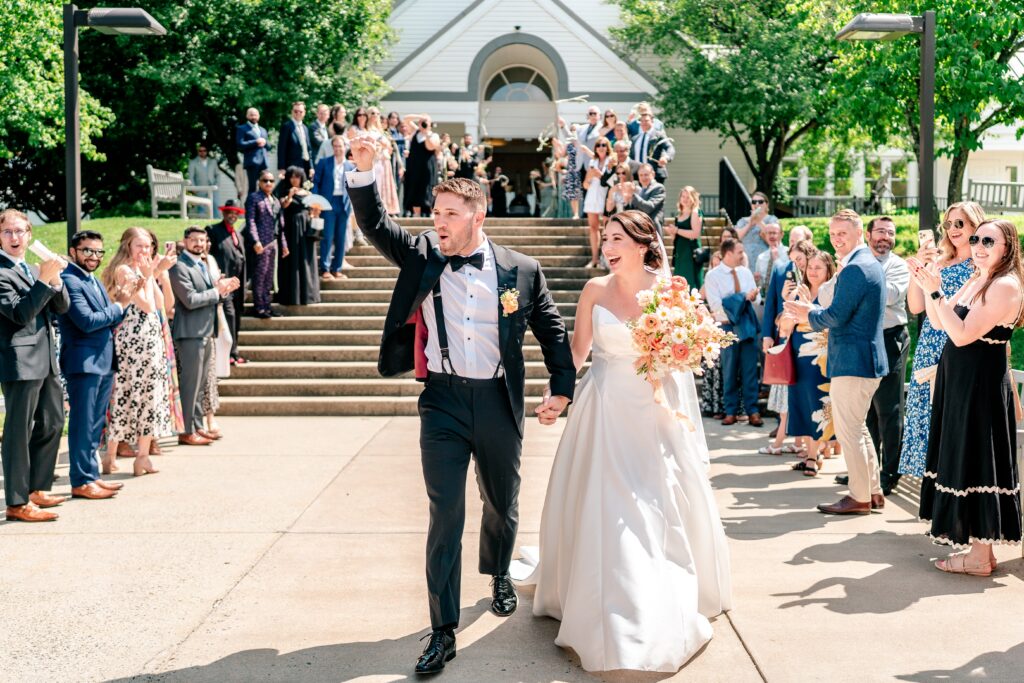 A groom waves to the crowd during their ribbon sendoff from the church wedding ceremony in Loudoun County