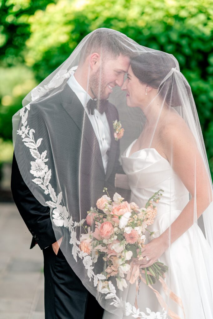 A bride and groom under the veil together at a Loudoun County wedding