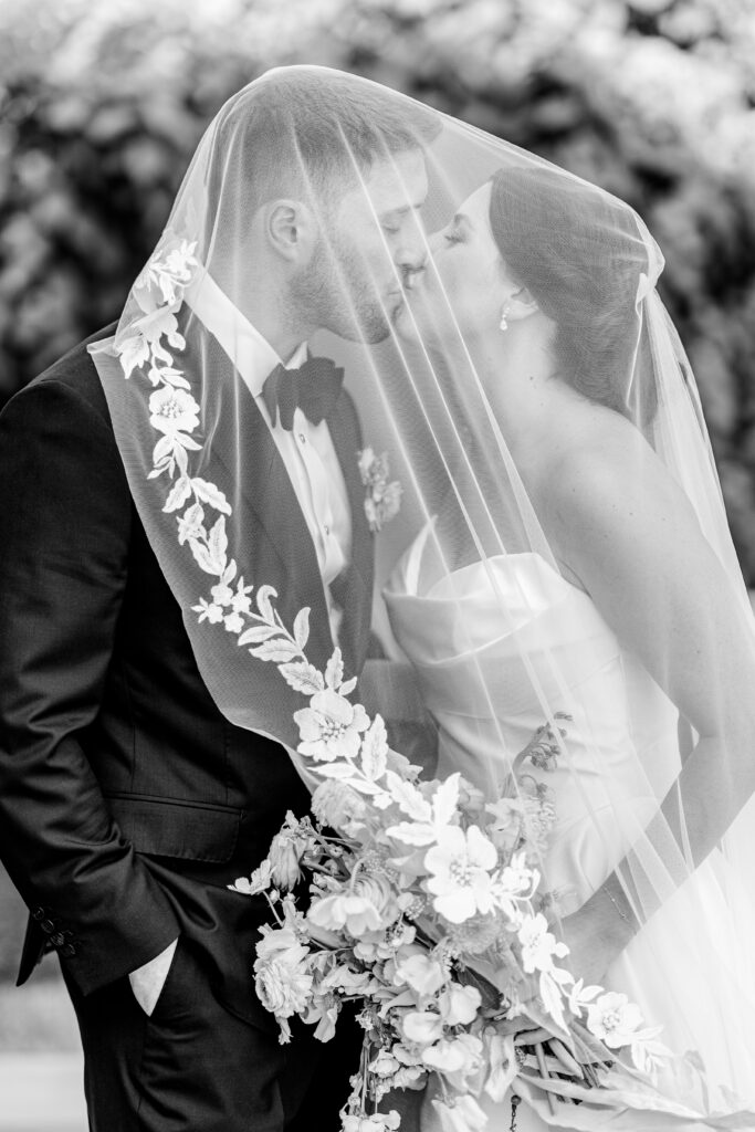 A bride and groom sharing a kiss under the veil