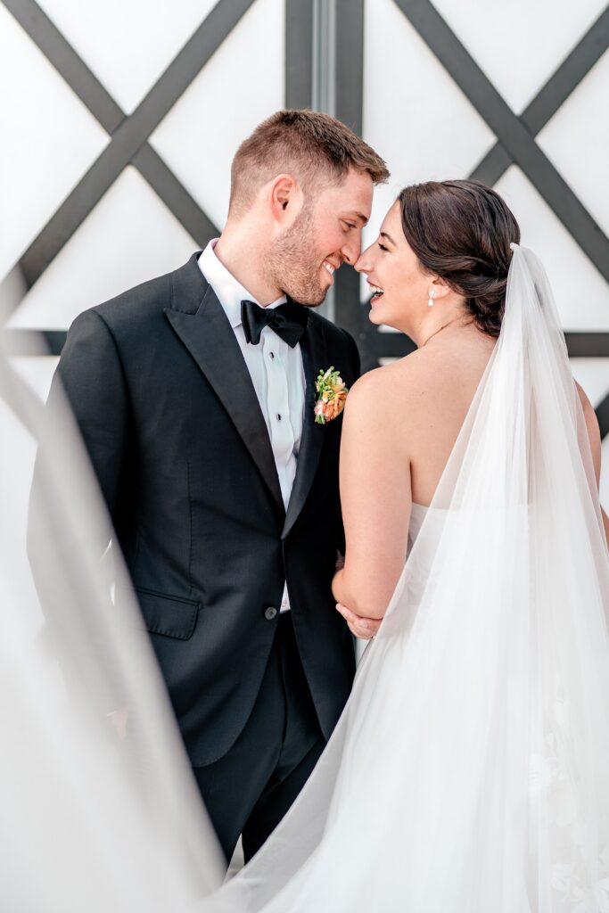 A bride and groom laughing while nose to nose after their St. Francis de Sales wedding
