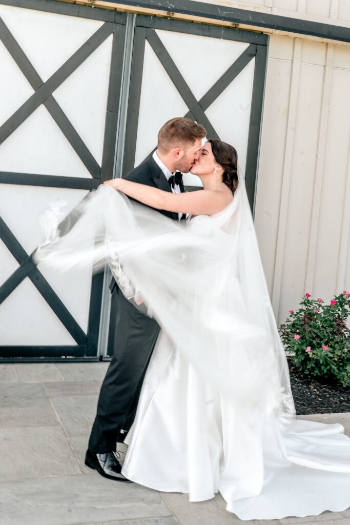 A Shadow Creek wedding portrait as the bride floats her veil around the couple sharing a kiss