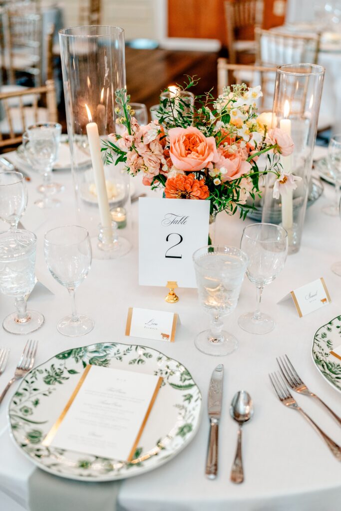 Beautiful reception details for a Loudoun County wedding including peach and pink floral centerpieces and green floral chargers