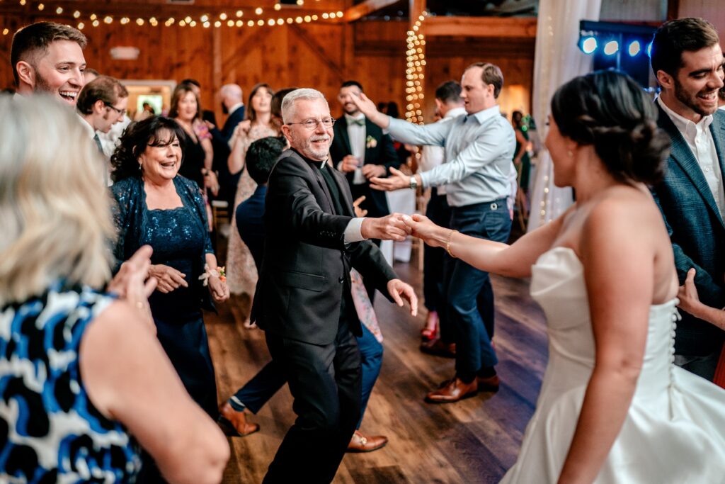 The bride dancing with a priest after a St. Francis de Sales wedding