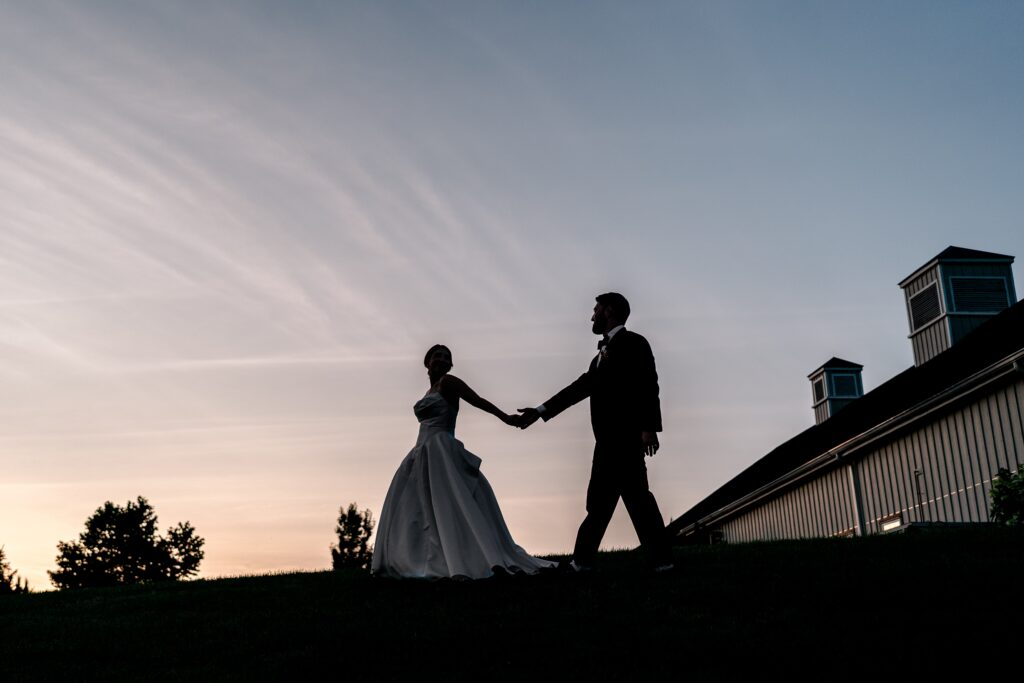 A silhouette portrait of a bride and groom at sunset