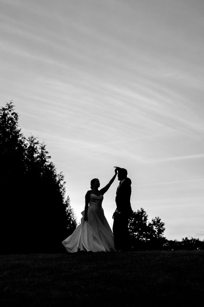 A silhouette of a groom twirling his bride for Shadow Creek wedding portraits