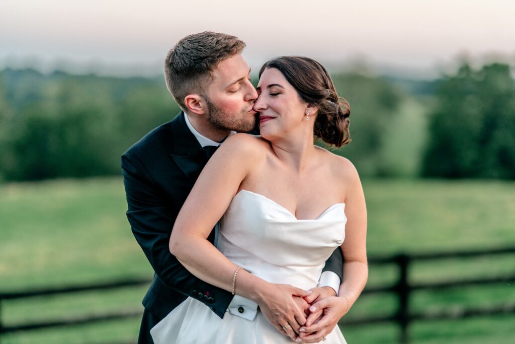 A groom kisses his bride on the nose in a portrait by their Northern VA wedding photographer
