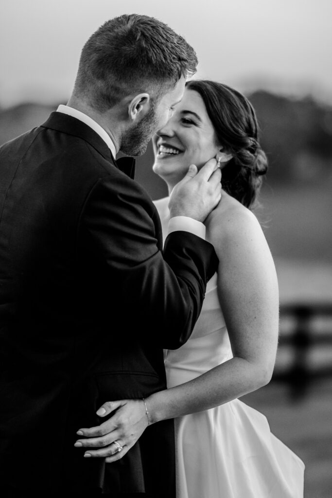 A bride smiles at her groom in a candid and intimate moment during their Shadow Creek wedding