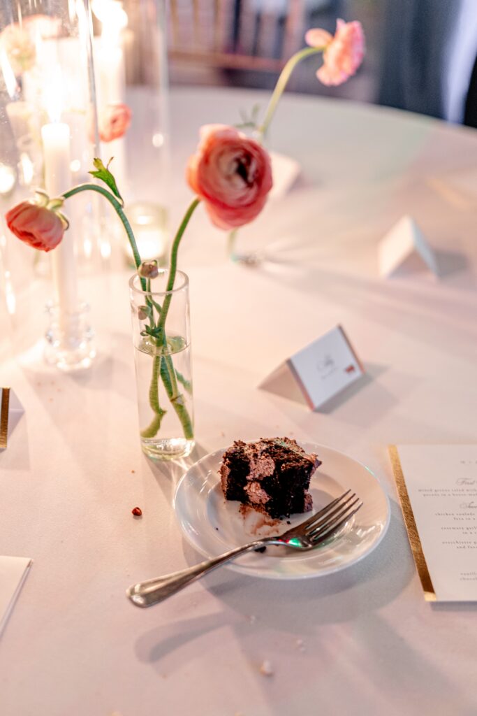 A piece of chocolate cake glowing in candlelight during a Loudoun County wedding reception