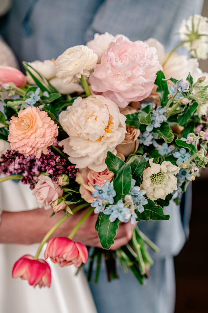 A lush colorful bridal bouquet including garden roses and pink tulips