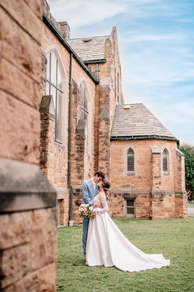 A bride and groom posed gracefully beside their church with their Northern VA wedding photographer