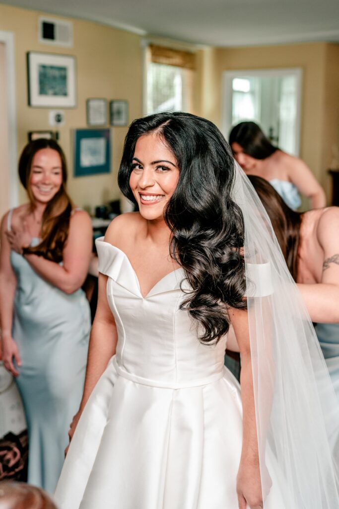 A bride surrounded by bridesmaids as she gets dressed for her Loudoun County wedding