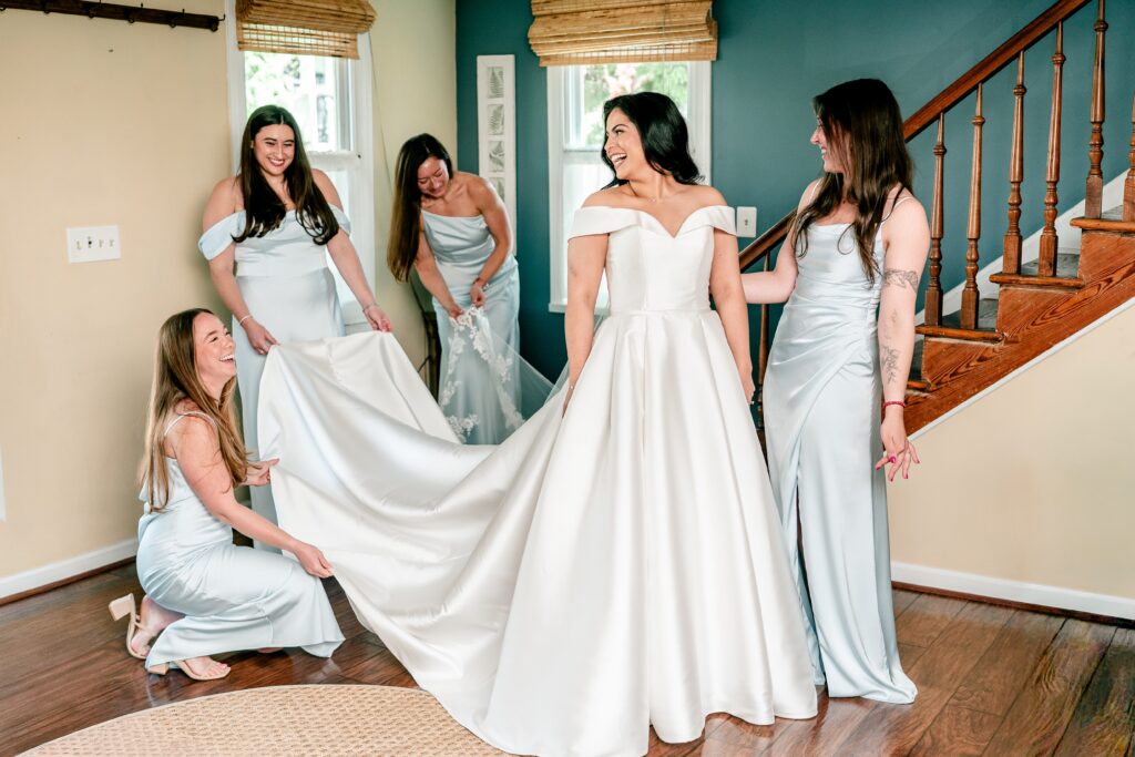 A bride surrounded by bridesmaids as she gets dressed