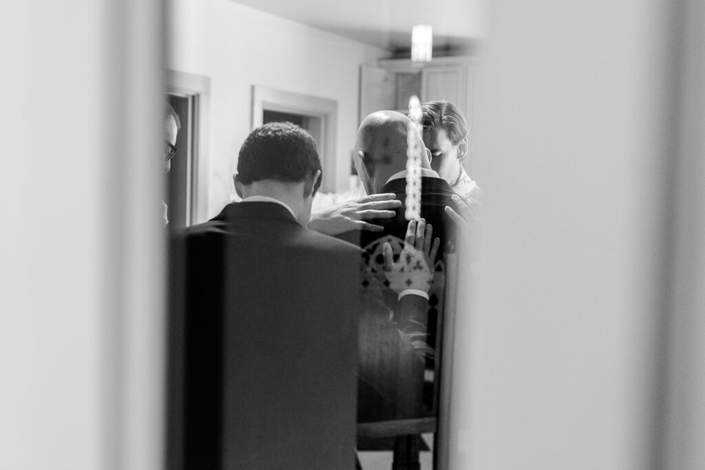 A groom being prayed over by his groomsmen before his Loudoun County wedding
