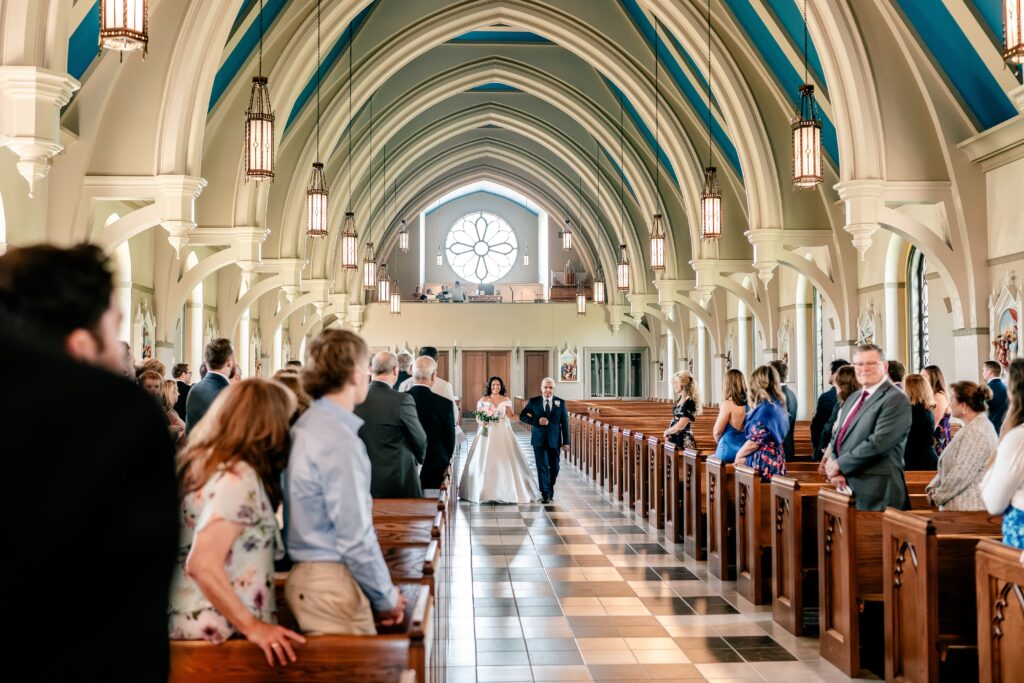 A bride walking down the aisle for her wedding at Corpus Christi Catholic Church in Aldie, VA
