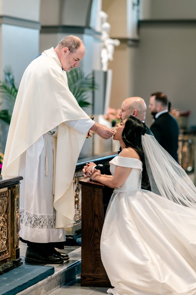 A bride receiving communion during her Loudoun County wedding ceremony