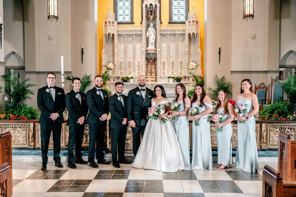 A wedding party posed for a classic portrait in front of the altar