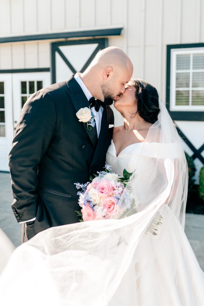 A bride and groom share a kiss at their Loudoun County wedding in the spring