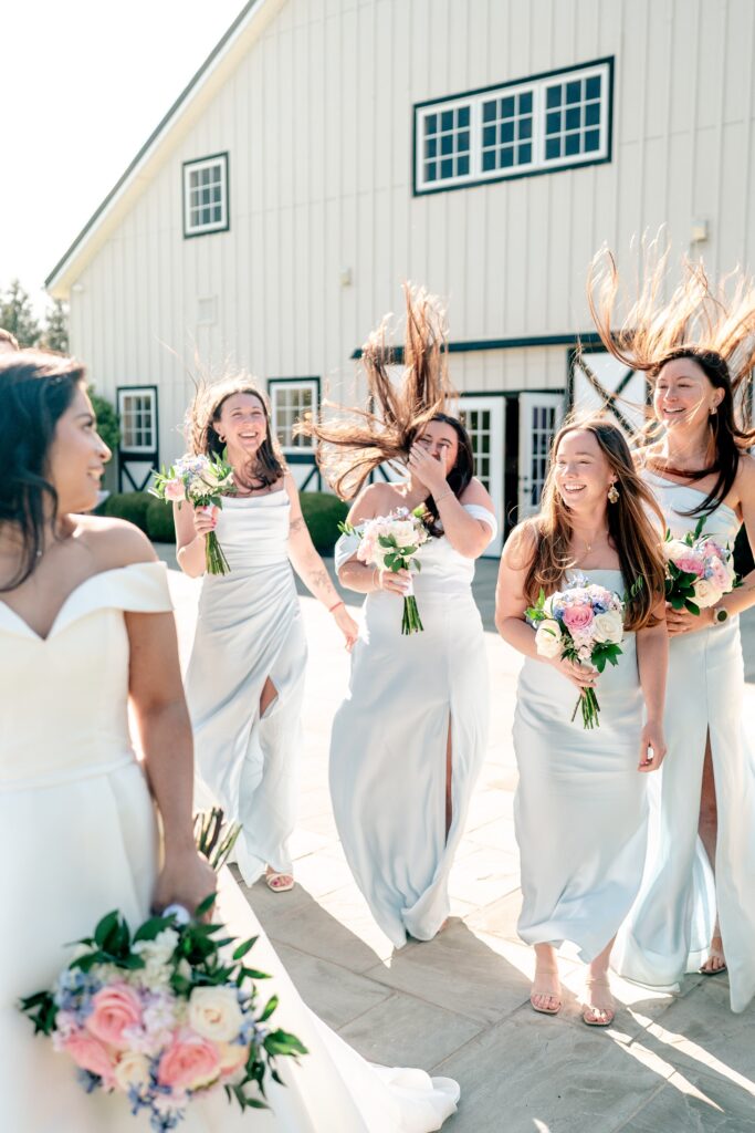 A funny wedding photo of the bridesmaids' hair flying around them due to wind during their portraits