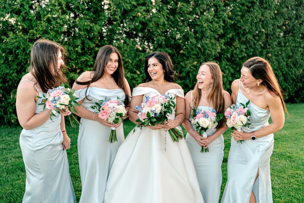A bride and her bridesmaids laughing together on her Loudoun County wedding day
