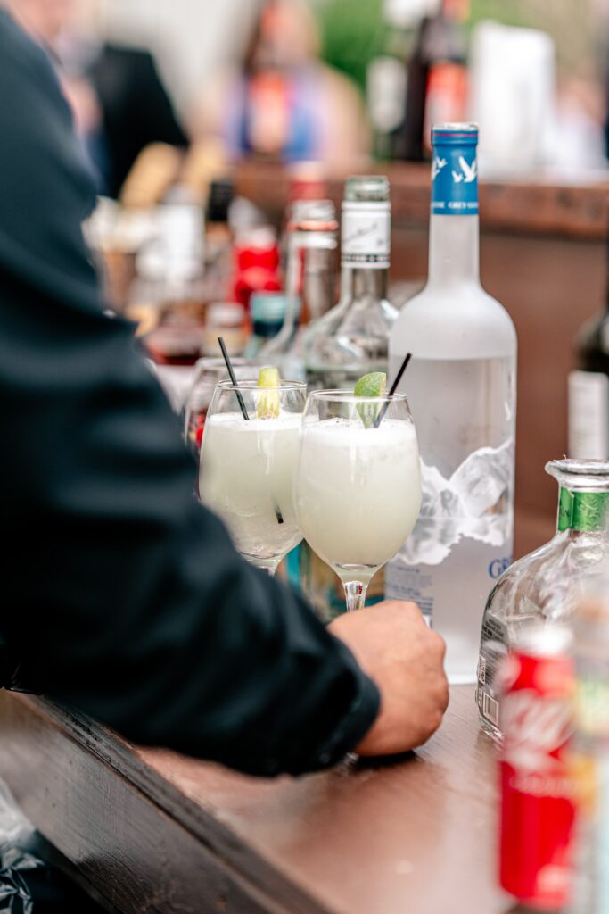 A bartender giving citrus-forward signature cocktails to guests at a wedding