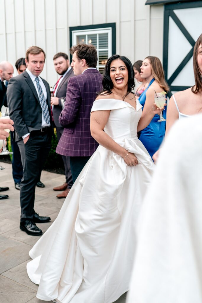 A bride smiling as she passes through a crowd at her Shadow Creek wedding cocktail hour