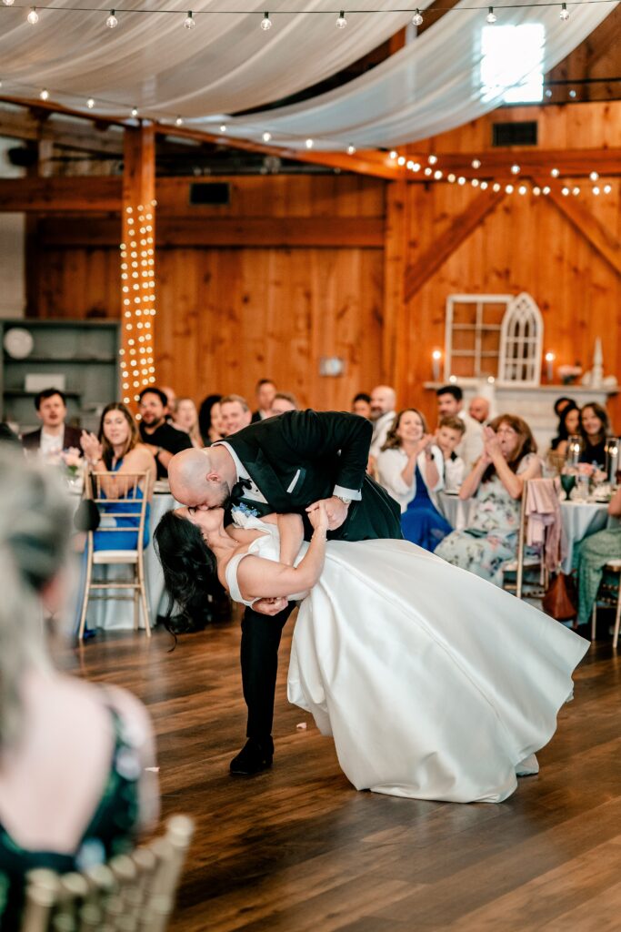 A bride and groom share a dip kiss to end their first dance