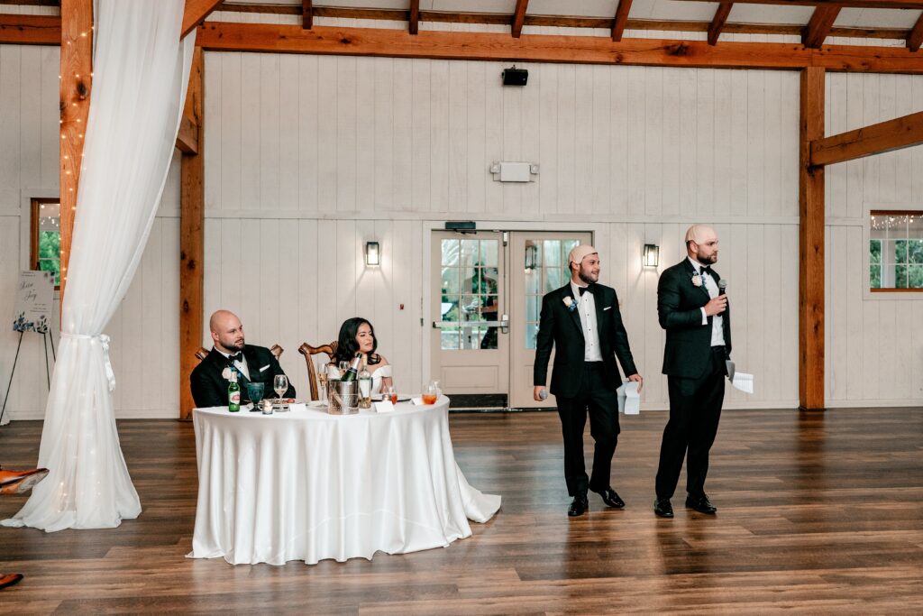 A pair of groomsmen giving a toast at a Loudoun County wedding reception