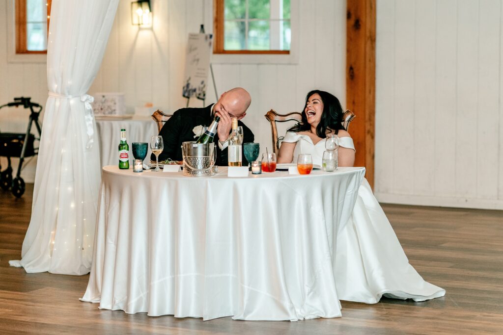A bride and groom laughing during toasts at a Shadow Creek wedding