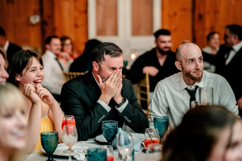 Wedding guests laughing during the toasts