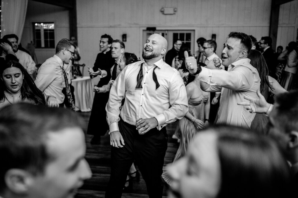 A groom laughing on the dance floor of his Loudoun County wedding