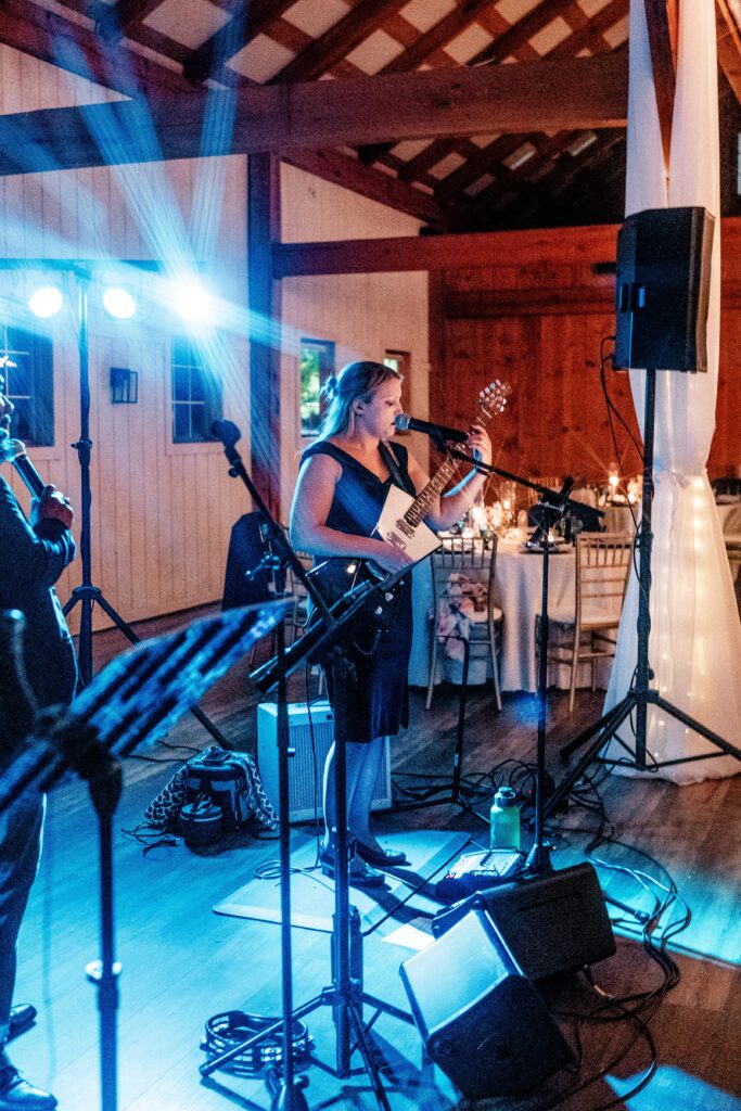 A musician performing with blue stage lights behind her during a Shadow Creek wedding reception